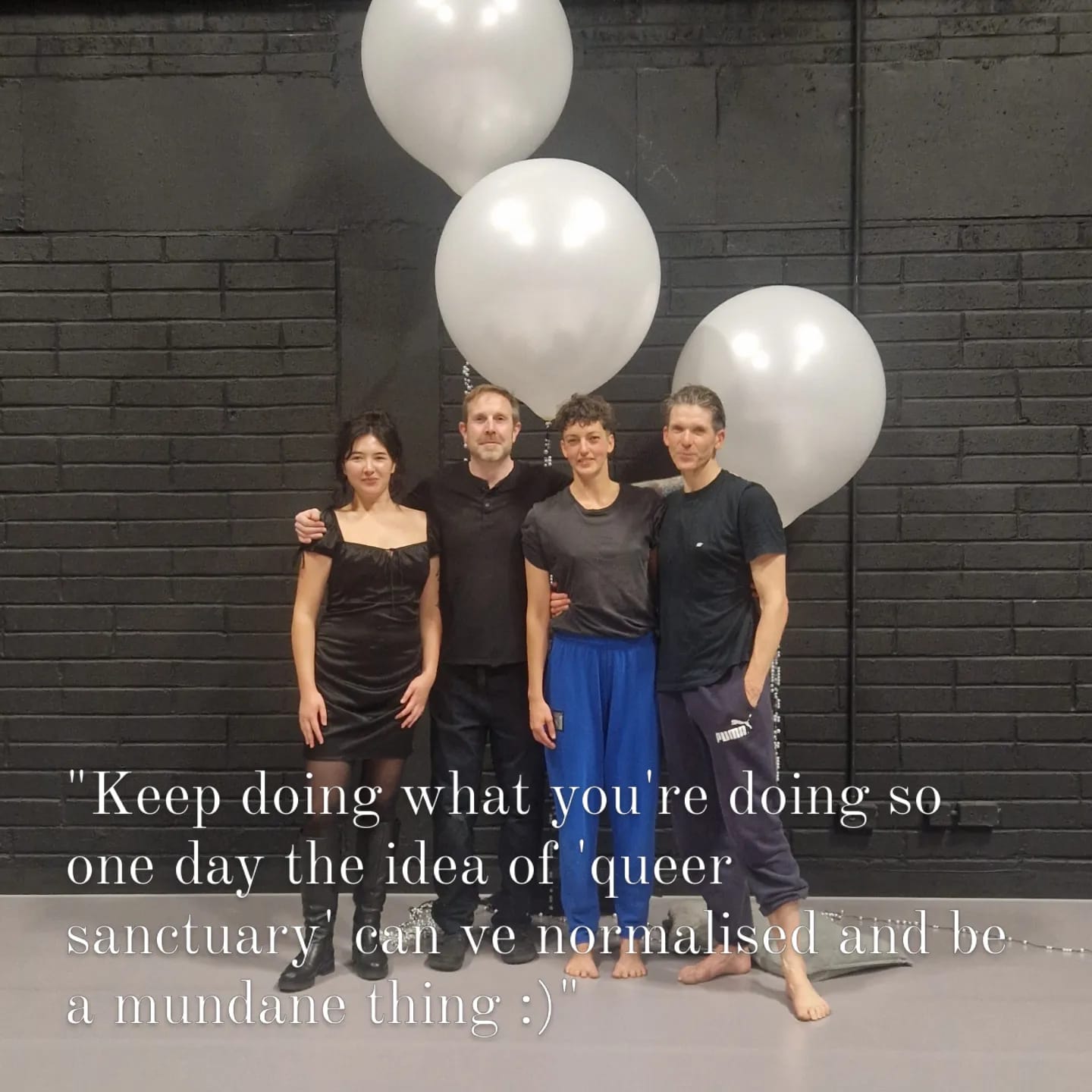 A team photo of four people standing in front of three white balloons/. The text reads: "Keep doing what you're doing so one day the idea of queer sanctuary can be normalised and be a mundane thing."